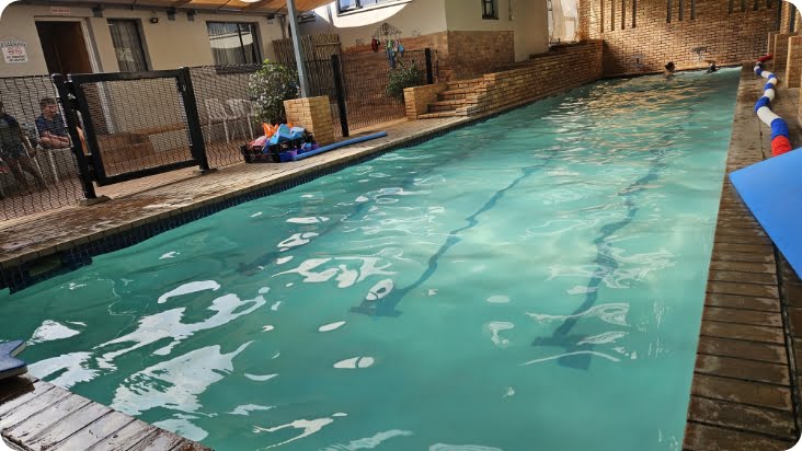 Indoor swimming pool at Zogs Swim School, featuring clear lanes, a safety gate, and a child-friendly environment.